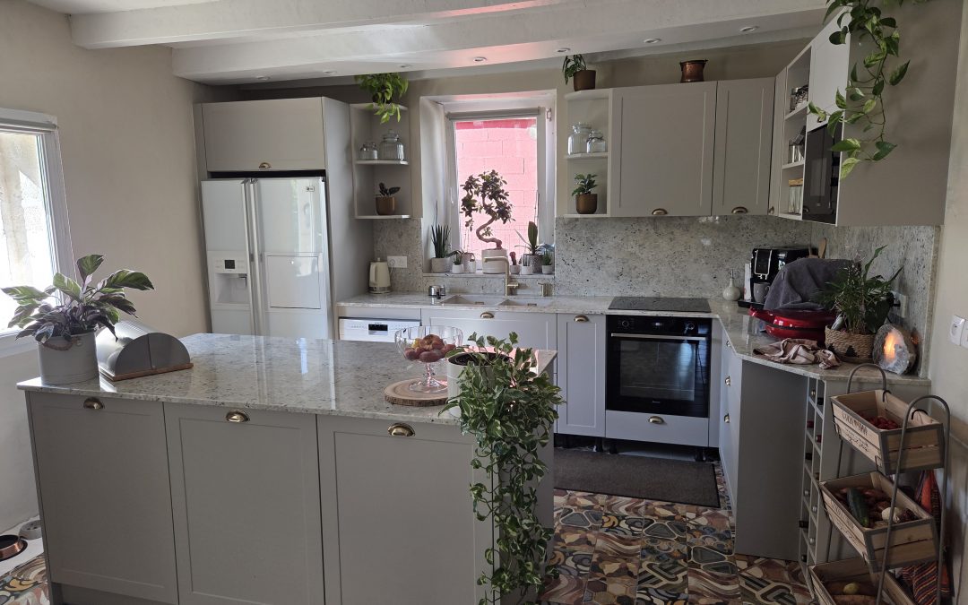 Cuisine à Saint-Jean-de-Lier avec façades beige mat, granit Colonial White, îlot central et équipements haut de gamme.